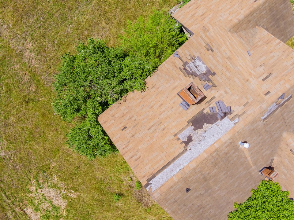 High winds and strong storms have damaged roof shingles from an aerial point of view